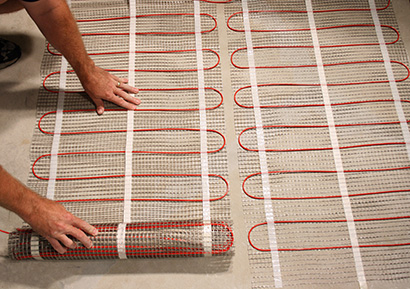 Installing ComfortTile electric radiant heating mats.